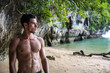 © theartofphoto - Half body shot of a handsome young man standing on a beach in Phuket Island, Thailand, shirtless wearing boxer shorts, showing muscular fit body