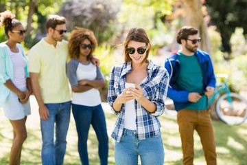 Sticker - Woman using mobile phone with friends in background