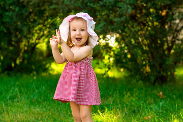 Smiling little girl in a meadow in the park.