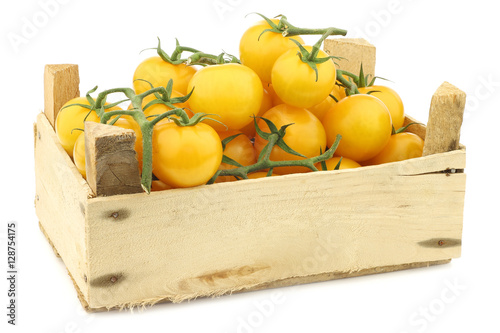 Fotografie, Tablou  fresh dutch yellow tasty tom tomatoes on the vine in a wooden crate on a white
