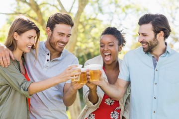 Wall Mural - Couple toasting a glasses of beer in park