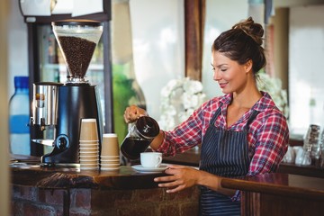 Wall Mural - Waitress preparing a coffee