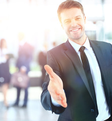 Wall Mural - Portrait of a successful businessman giving a hand