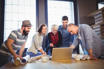 Creative business people discussing over laptop 