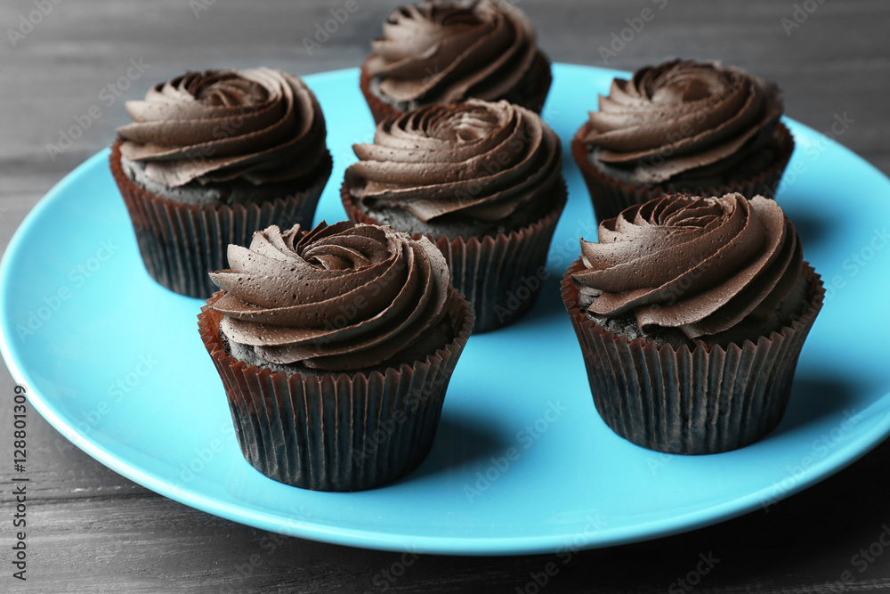 Tasty cupcakes on blue plate
