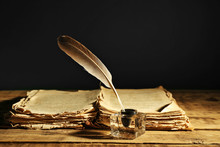 Feather Pen With Inkwell And Stack Of Papers On Dark Background