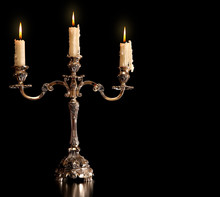 Burning Old Candle Vintage Bronze Silver Candlestick. Isolated Black Background.