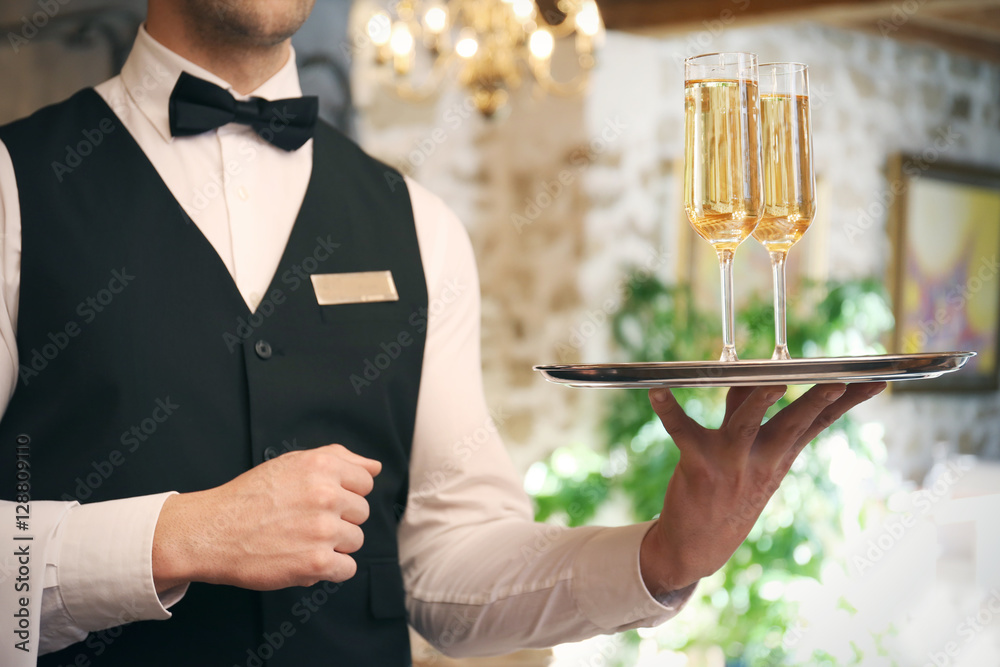Waiter serving champagne at restaurant, close up view