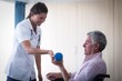 © WavebreakmediaMicro - Female doctor assisting senior man in lifting dumbbell