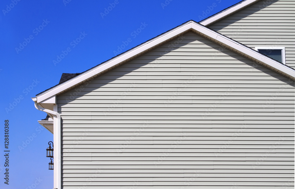 New home with gray vinyl siding and blue sky in the background  - obrazy, fototapety, plakaty 