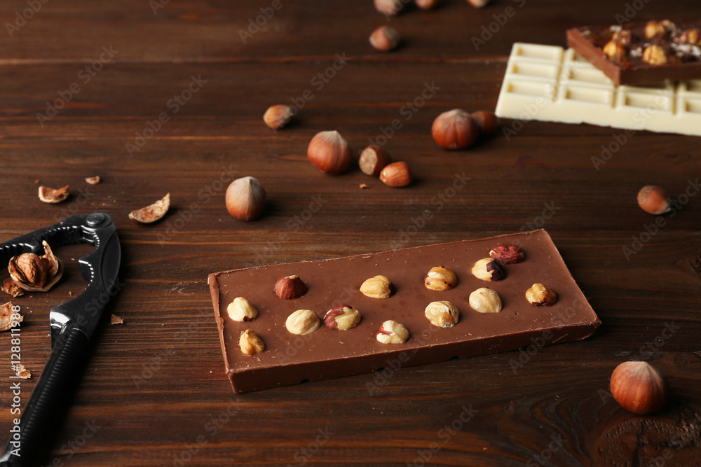 Milk chocolate with nuts on wooden table