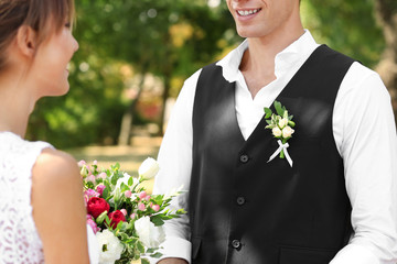 Poster - Groom and bride with wedding bouquet in park, closeup