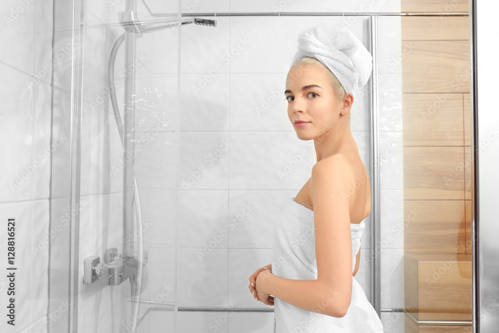 Beautiful young woman in towel going to shower