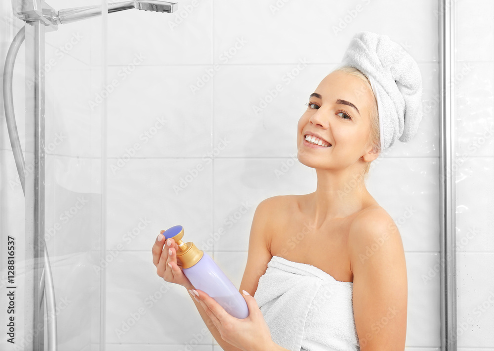 Beautiful young woman in towel going to shower