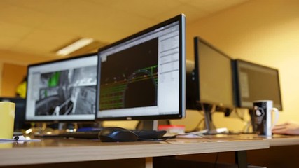 Engineer office screens. Empty computer and blurred person working in background