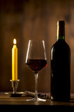 Fototapeta  - Pouring red wine into wineglass from green bottle