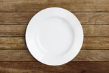 Fototapeta  - Simple white circular porcelain plate on wood with clipping path