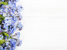 Blue Flowers Frame On White Wooden Background