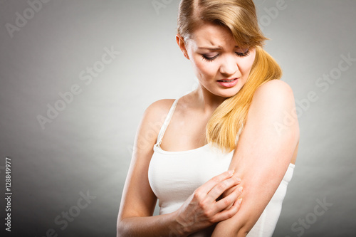 Foto woman scratching her itchy arm with allergy rash