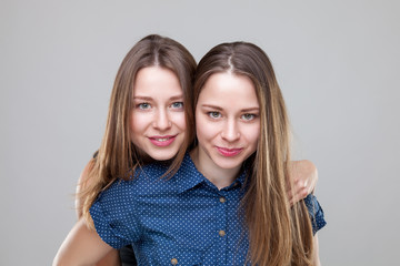 Studio portait of young twin sisters embracing