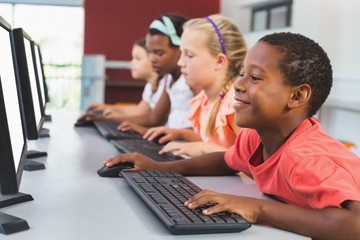 School kids using computer in classroom