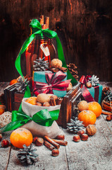 Wall Mural - Christmas composition, Tangerines, pine Cones, Snow,decor, Bunch of Cinnamon, Walnut.Brown Wooden Background.Vintage old lantern.New Year Card
