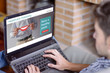 © GENETTICA - Young man at home using laptop with healthcare videoblog on the screen. All screen graphics are made up.