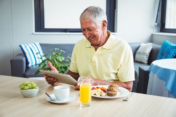 Wall Mural - senior man using a digital tablet