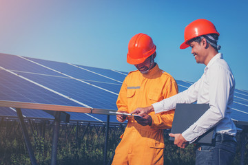 Wall Mural - engineer working on checking and maintenance equipment at industry solar power; engineer and technician discussion plan to find problem of solar panel and feeling joyful