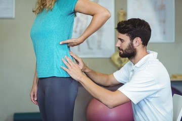 Wall Mural - Physiotherapist examining womans back 