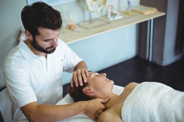 Wall Mural - Portrait of smiling physiotherapist sitting with spine model