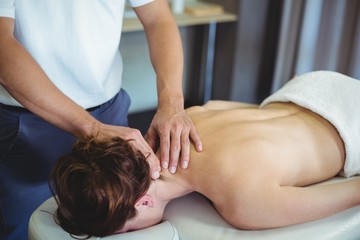 Wall Mural - Physiotherapist giving neck massage to a woman