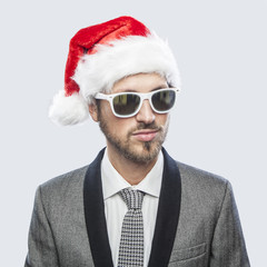 Wall Mural - Young cool man with Santa Claus hat and sunglasses