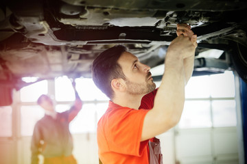 Wall Mural - Car mechanics working and maintaining car