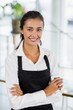 © WavebreakmediaMicro - Portrait of smiling waitress standing with arms crossed
