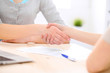© rogerphoto - Young business woman shaking hands  after signing contract
