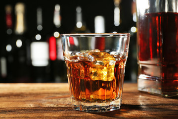 Poster - Glass of whisky on wooden bar closeup