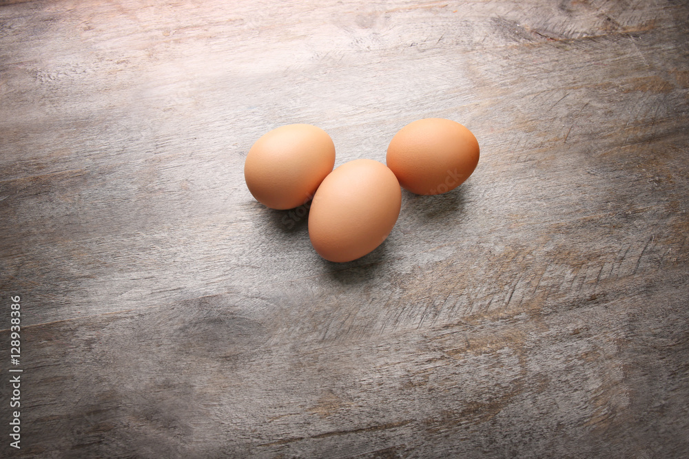 Raw eggs on wooden background