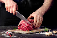 Man Cutting Raw Beef Meat