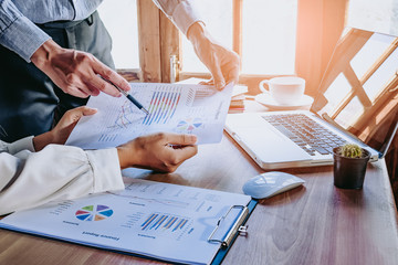 Business team analyzing income charts and graphs with modern laptop computer. Top view close up