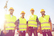 © Syda Productions - group of smiling builders with tablet pc outdoors