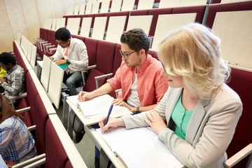 Canvas Print - group of students with notebooks at lecture hall