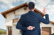 © Catalin Pop - Back view of male realtor with finger crossed