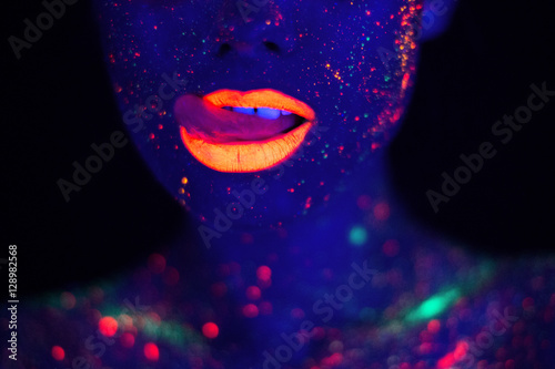 Zdjęcie XXL Portret pięknej kobiety mody w świetle neonowym UF. Modelka z fluorescencyjnym, kreatywnym psychodelicznym makijażem, projekt artystyczny modelki tancerki disco w UV, kolorowy abstrakcyjny makijaż