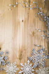 Silver snowflakes and decorative twig on a wooden table. Christm