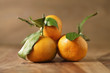 © GCapture - organic fresh tangerines with leaves on wooden table, shallow focus