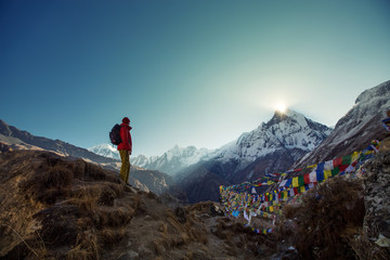tourist man watching sunrise over the sacred mountain machapuchare from annapurna base camp in himal