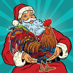 Wall Mural - Santa Claus holds in his hands the cock