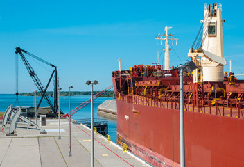 St. Lawrence River Locks:  A crane-operated barrier bar rises and a lock exit gate swings open to allow westward passage for a large freight ship on the St. Lawrence River at Massena, New York.
