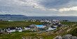 Bonavista, Newfoundland, Canada, mid summer, overcast day.   Seaside village community.  People staying inside on blustery day except one man working on his roof.